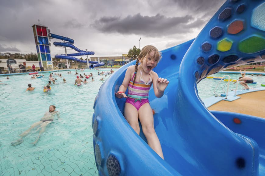 Girl enjoying one of the slides at Laugardalslaug, a community pool in Reykjavik, Iceland
