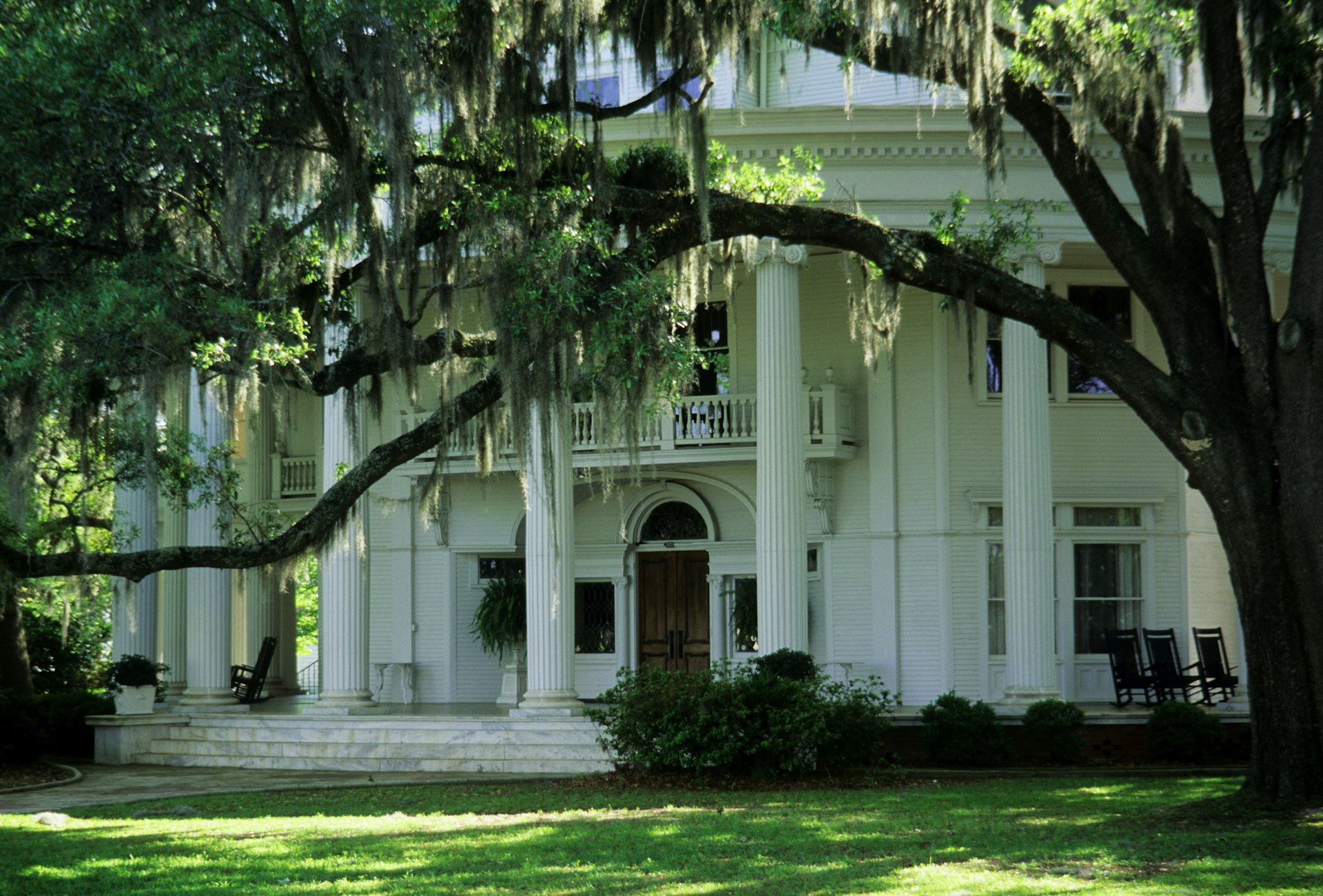 The white columns of The Crescent mansion behind floating Spanish moss, Valdosta