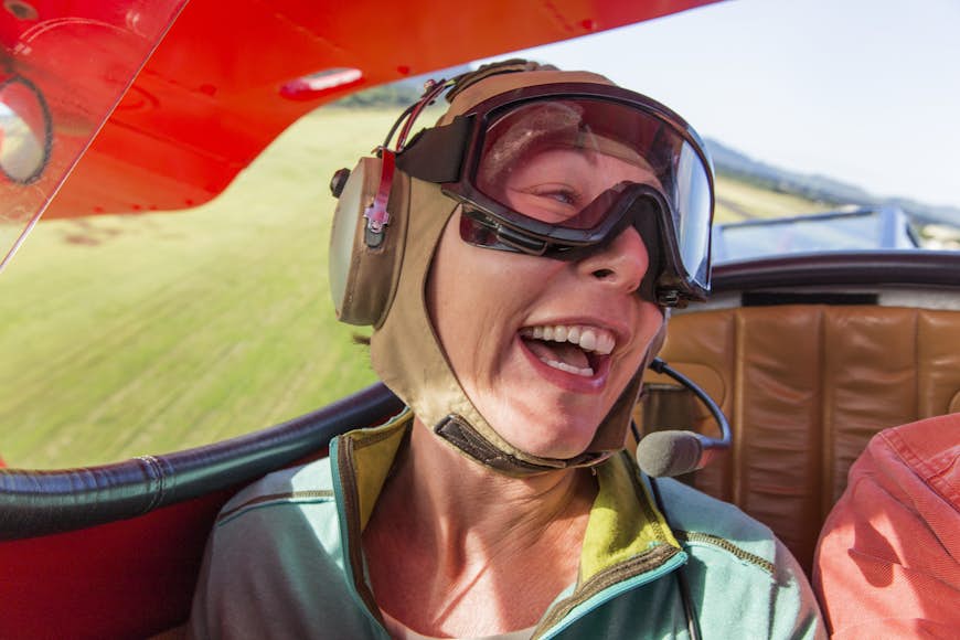 A woman laughs as she flies in a biplane over Kaua‘i, Hawai‘i