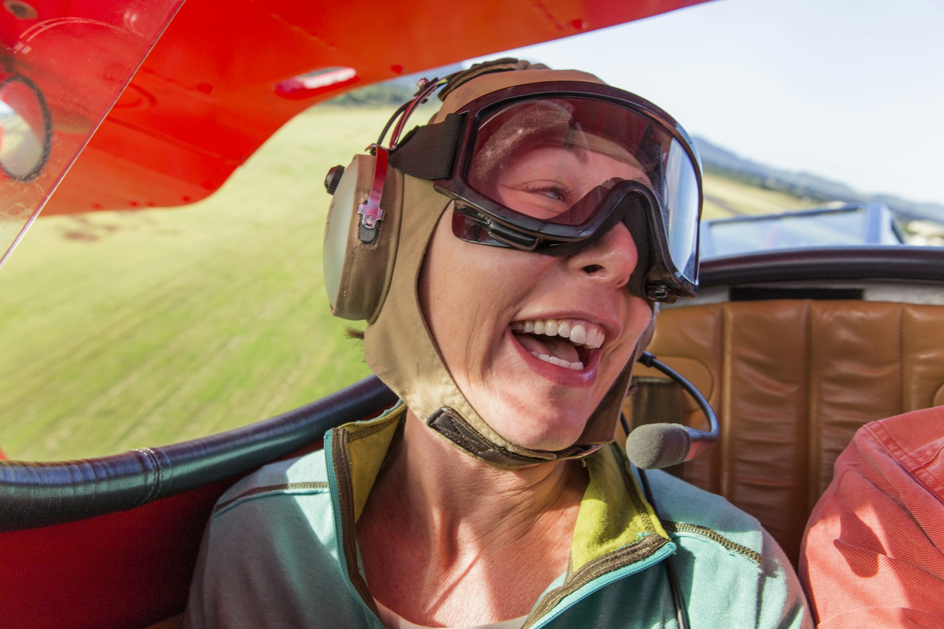 A woman laughs as she flies in a biplane over Kaua‘i, Hawai‘i