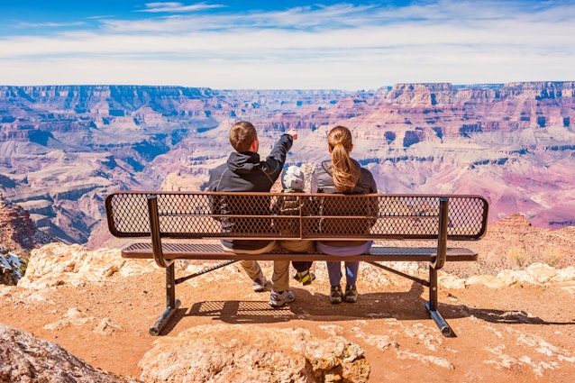 一个阳光明媚的日子，一个孩子的库存照片，一个孩子，有一个孩子，看着美国南部边缘的大峡谷国家公园的景色。