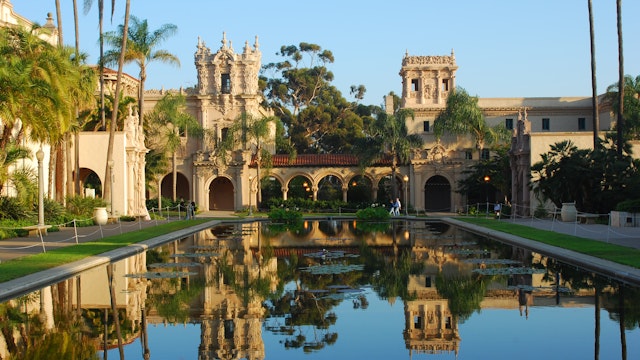 Balboa Park with buildings reflected in still water.