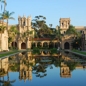 Balboa Park with buildings reflected in still water.