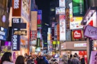 Seoul, South Korea - February 14, 2013: Crowds pass under the Myeong-Dong neon lights. The location is the premiere district for shopping in the city.