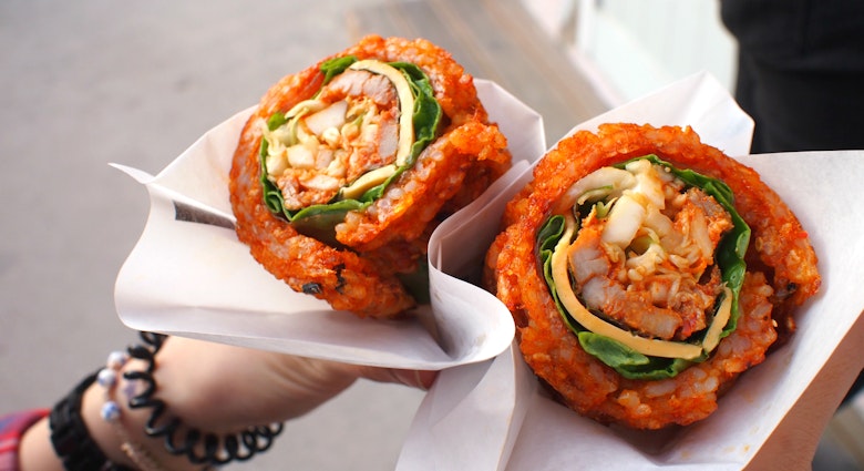Bibimbap waffle at Hanok village, South Korea. It is composed of spicy rice rolled around a filling - pieces of meat, vegetables, cheese, and rice paper.