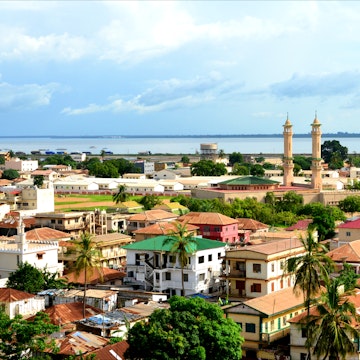 Skyline of the low-rise Gambian capital with the River Gambia and the minarets of King Fahad Mosque on the right.