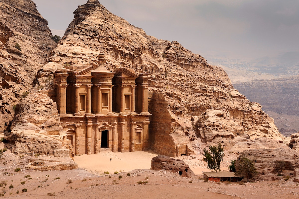 There is a person by the doorway to get a scale of the size. A classic view of El Deir, The Monastery in Petra. Shown in the context of the mountain that the facade was carved out of by the Nabataeans in the 1st century. The facade measures 50 metres wide by approximately 45 meters high.