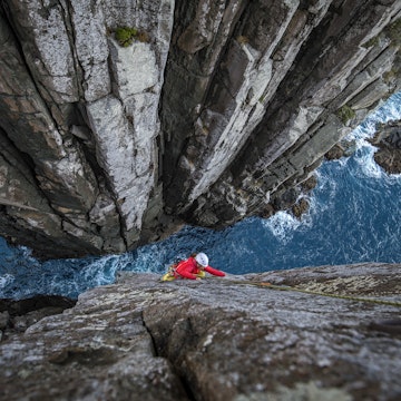 A female climber on the second pitch of the Totem Pole near Cape Hauy, Tasman Peninsula, Tasmania, Australia.
