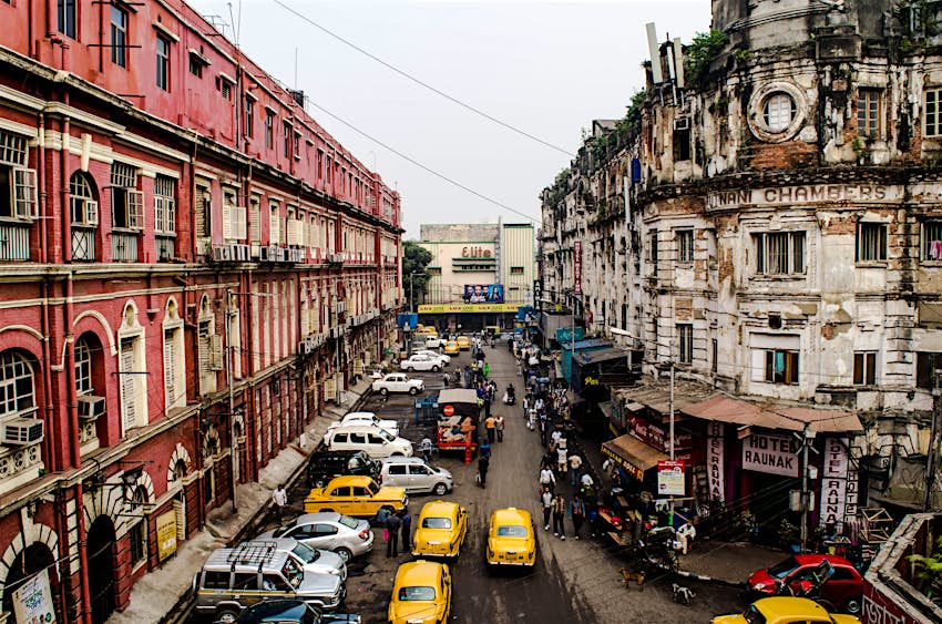 Old buildings lining the Kolkata’s streets, filled with traffic and signature yellow taxis