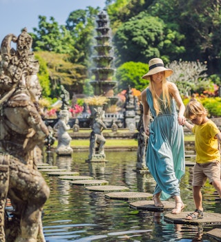 Mom and son tourists in Taman Tirtagangga, Water palace, Water park, Bali Indonesia. Traveling with children concept. Kids friendly place; Shutterstock ID 1477605794; your: Claire N; gl: 65050; netsuite: Online ed; full: Indo things to know