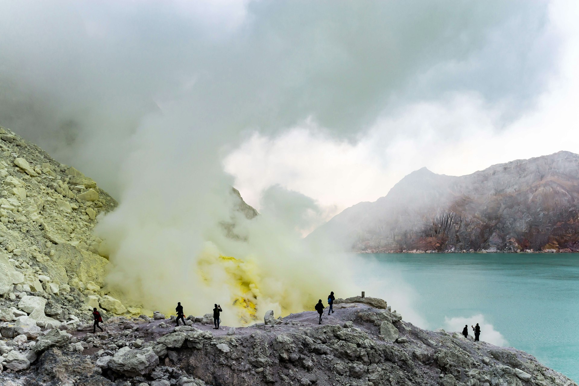 Tourists walking to see the sulfur mines and blue green lakes in Ijen crater, Indonesia