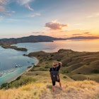 A man with his hand on his hat, looking out from Gili Lawa in Komodo National Park