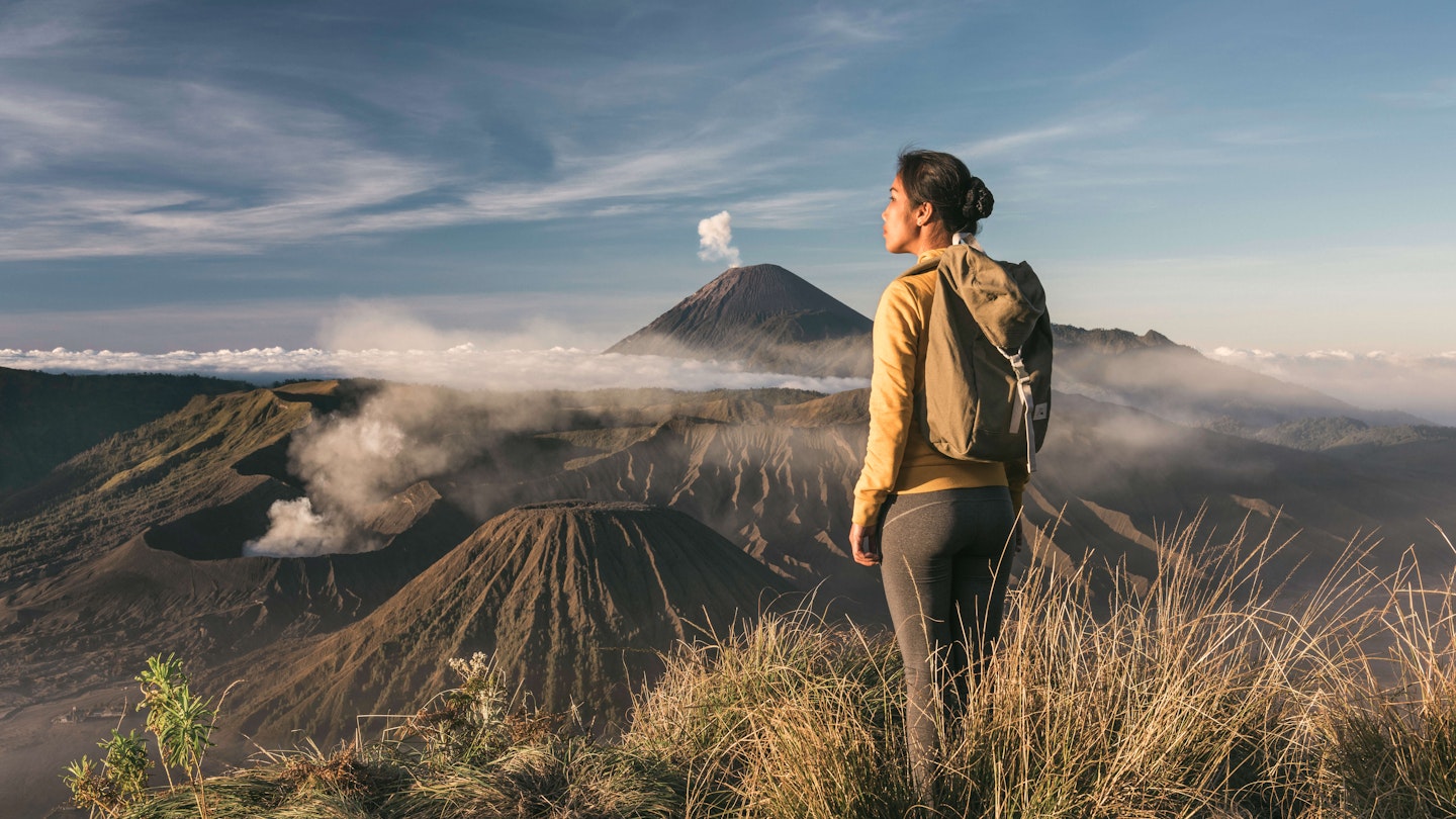 woman standing infront of mount bromo - stock photo
asia, indonesia, java, asian woman standing infront of mount bromo and mount semeru, admiring the view at sunrise
