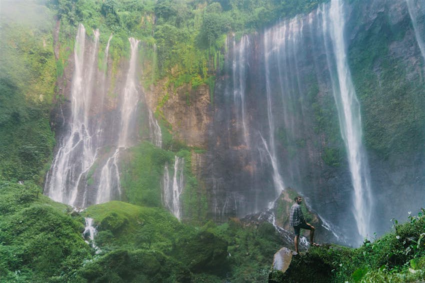 Man standing and looking at Tumpak Sewu waterfall in Java 