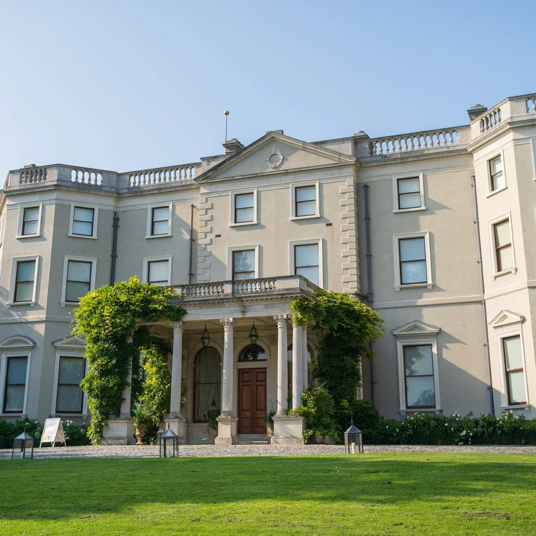 Wide view of Farmleigh house, a historic house, estate and working farm is the official Irish state guest house, in Phoenix Park, Dublin, Ireland. Shot on a sunny day with blue skies and lots of foliage
