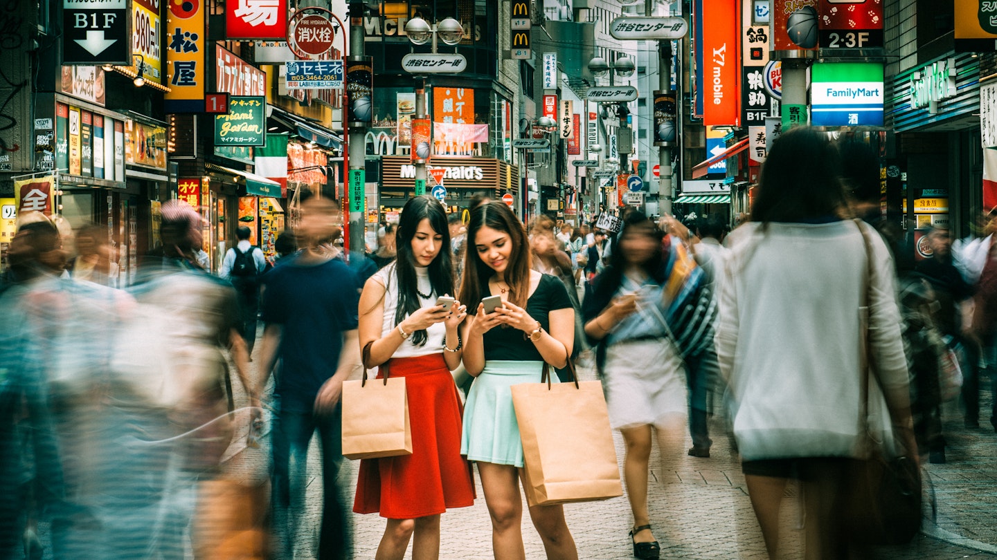 Japanese girlfriends hanging out on Shibuya streets of Tokyo. Japan.