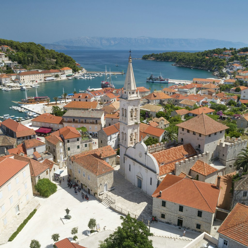 Unique aerial of the beautiful croatian harbor town Jesla with its famous St. Mary’s Church. Located on the Island Hvar in the Adriatic Sea. Croatia. You can even see the Croatian Mainland in back. Converted from RAW.