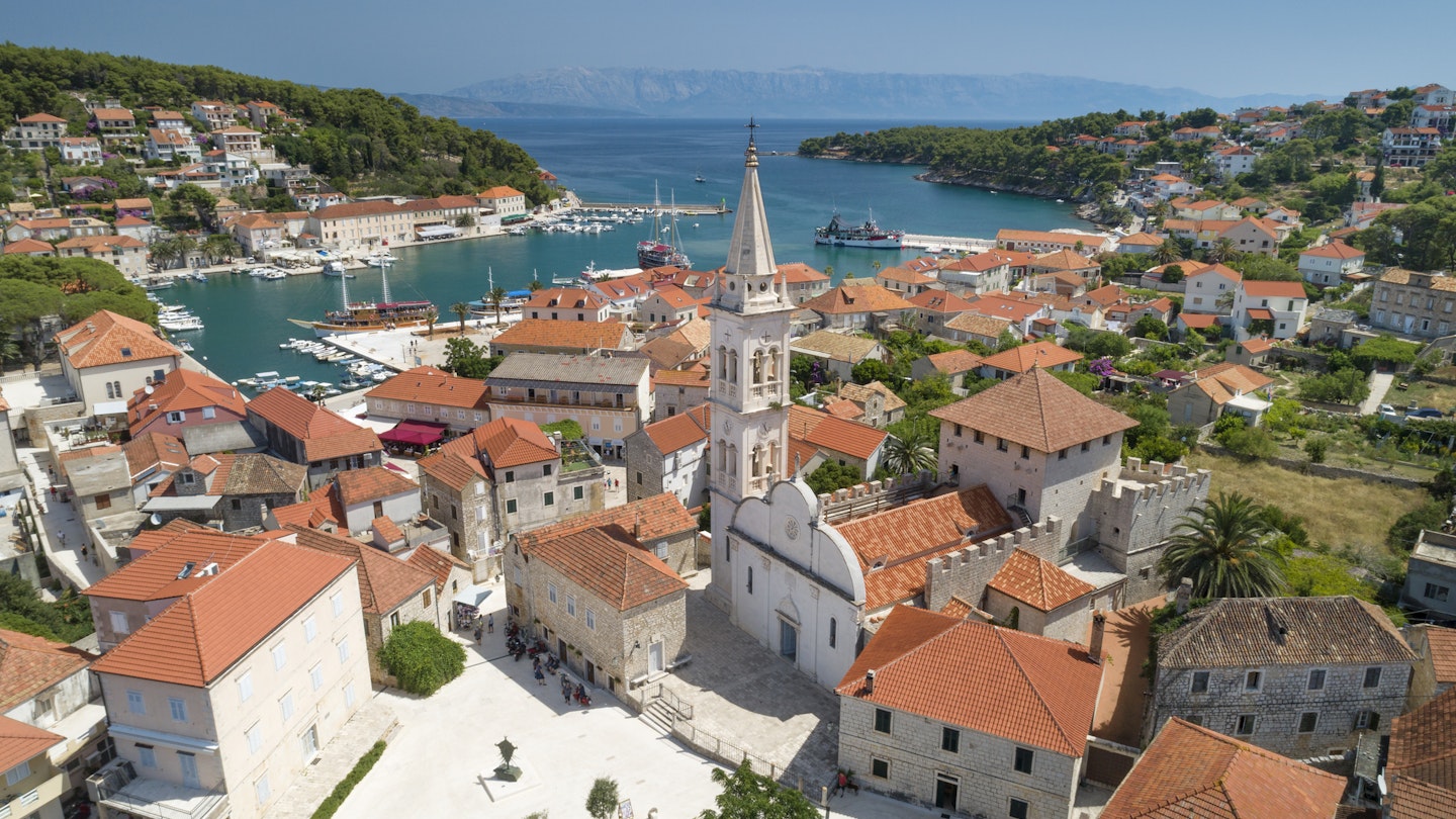 Unique aerial of the beautiful croatian harbor town Jesla with its famous St. Mary’s Church. Located on the Island Hvar in the Adriatic Sea. Croatia. You can even see the Croatian Mainland in back. Converted from RAW.