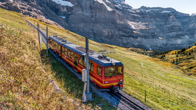 The red train running on the Jungfrau railway with a background view of Jungfrau