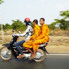 Monks riding on motorcycle.