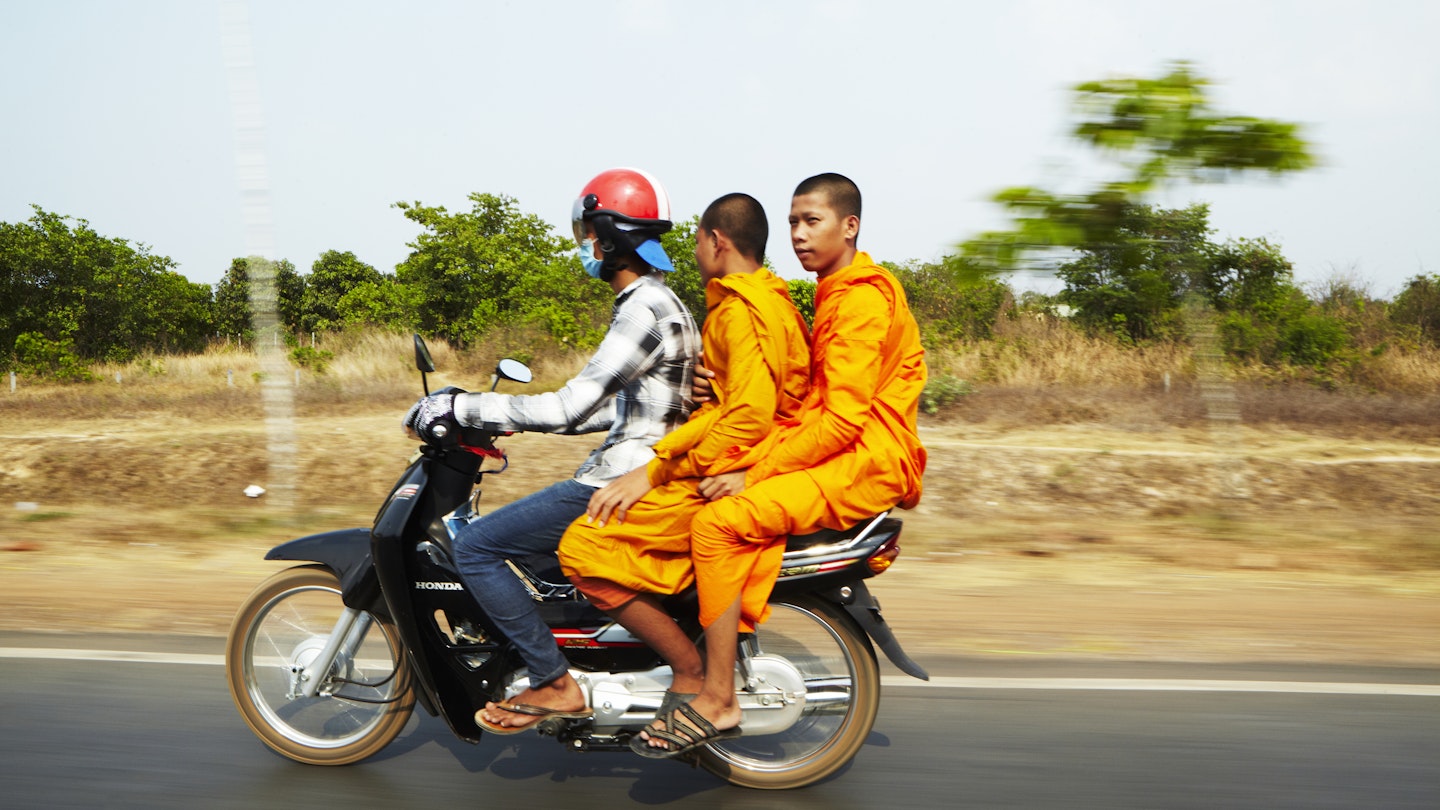 Monks riding on motorcycle.