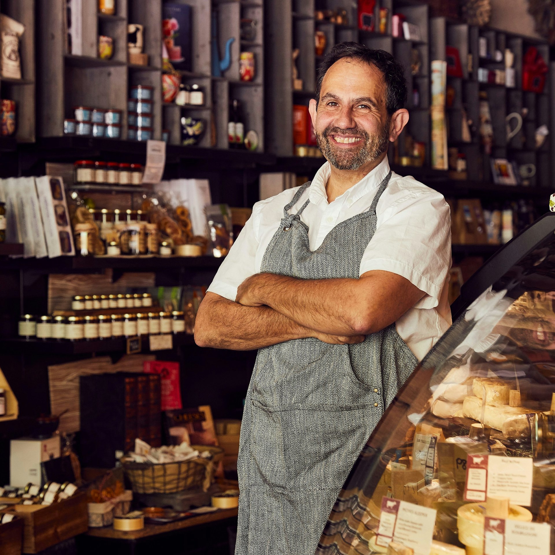 Ken Monteleone of Fromagination, surrounded by displays of cheese, jams and other artisanal products