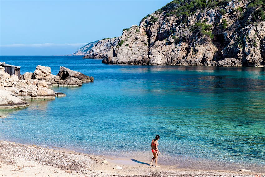 Moteris tikrina vandenį nuošaliame Cala d'en Serra paplūdimyje šiauriniame Ibisos krante.