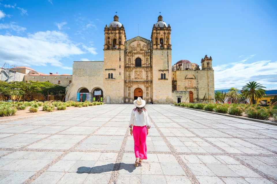 A woman walking toward the Church of Santo Domingo de Guzman, Oaxaca, Mexico.