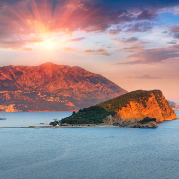 Panoramic landscape of coast Budva riviera:Sveti Nikola island and mountains at sunset. Dramatic evening sky. Balkans, Adriatic sea, Europe.
Landscape of coast Budva riviera:Sveti Nikola island at sunset. - stock photo
