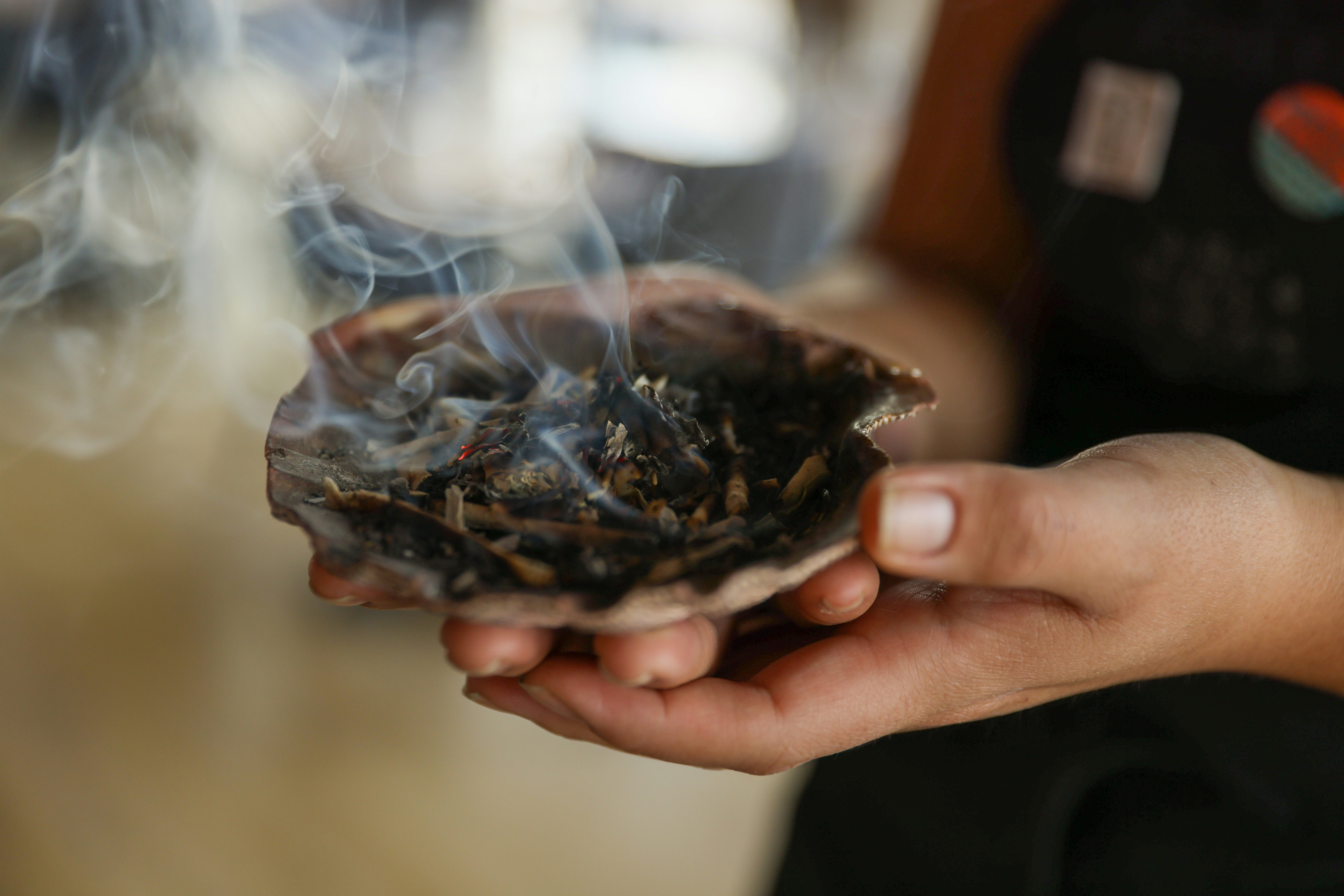 Smudging the restaurant Owamni by The Sioux Chef with sage from a shell