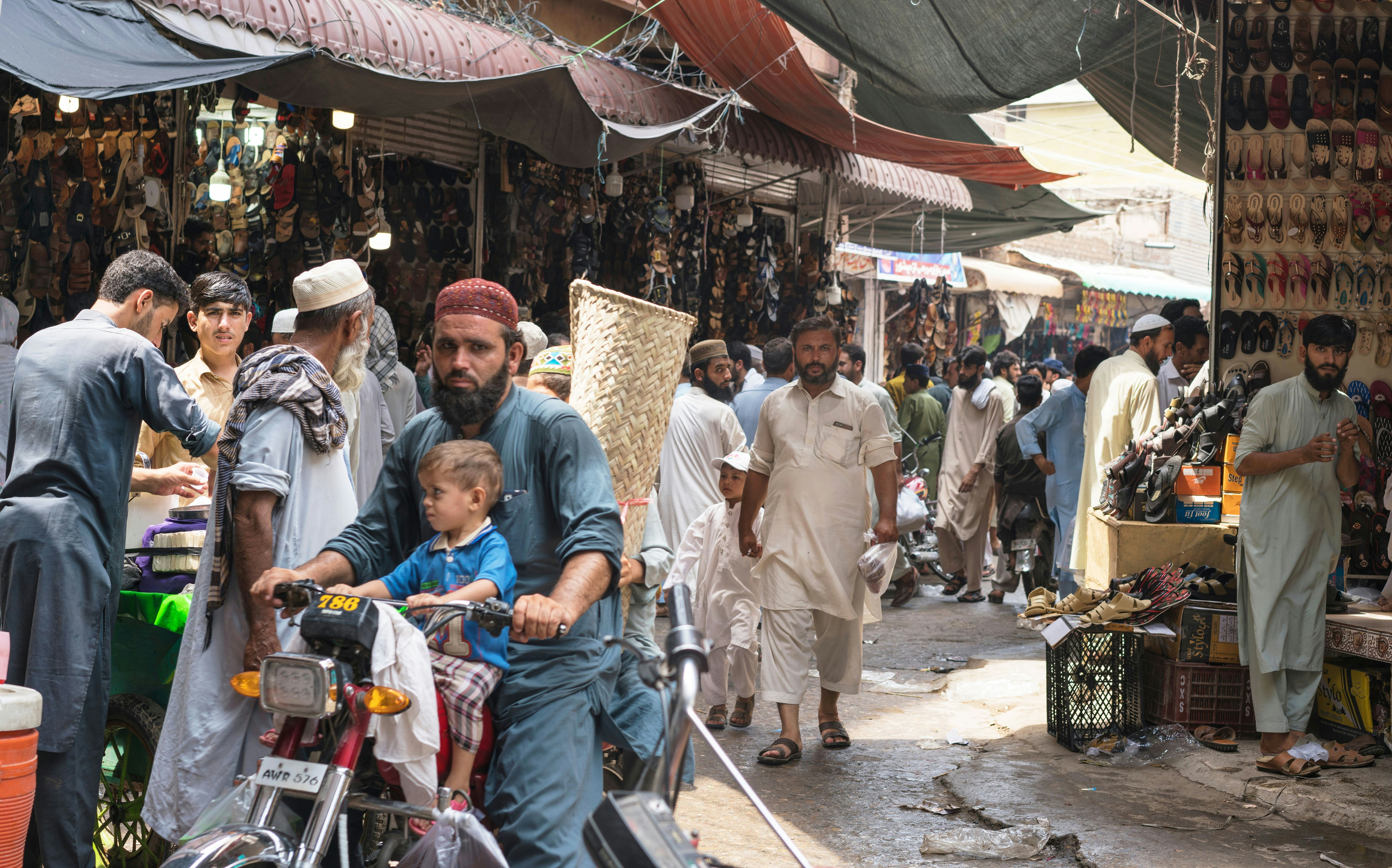 Karkhanai Bazaar, Peshawar/Pakistan-August 11, 2019: man and his son  are driving bike at the streets of Karkhanai bazaar (smugglers bazaar), Peshawar, Pakistan; Shutterstock ID 1500892436; your: Bridget Brown; gl: 65050; netsuite: Online Editorial; full: POI Image Update