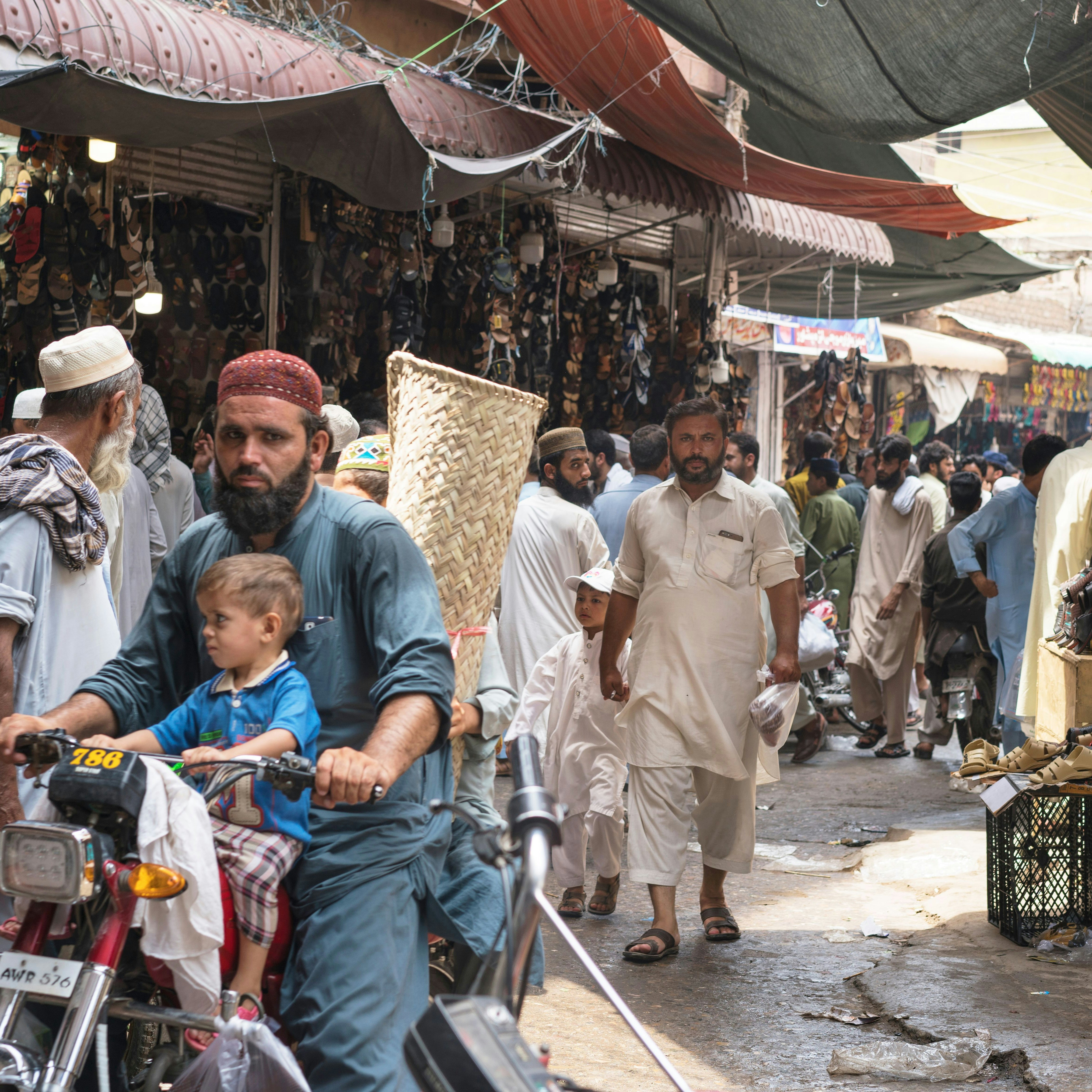 Karkhanai Bazaar, Peshawar/Pakistan-August 11, 2019: man and his son  are driving bike at the streets of Karkhanai bazaar (smugglers bazaar), Peshawar, Pakistan; Shutterstock ID 1500892436; your: Bridget Brown; gl: 65050; netsuite: Online Editorial; full: POI Image Update