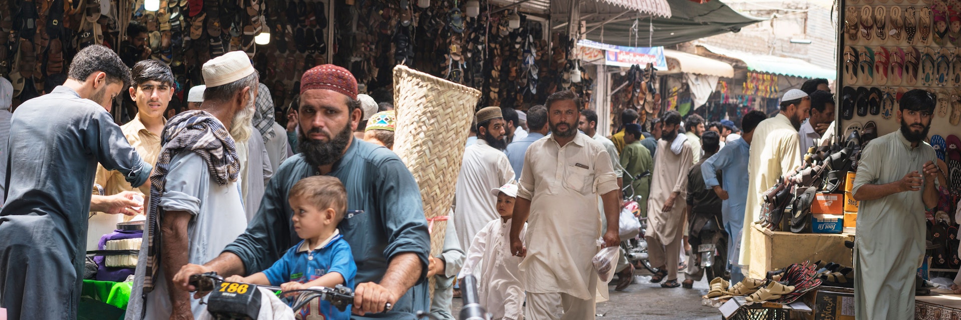 Karkhanai Bazaar, Peshawar/Pakistan-August 11, 2019: man and his son  are driving bike at the streets of Karkhanai bazaar (smugglers bazaar), Peshawar, Pakistan; Shutterstock ID 1500892436; your: Bridget Brown; gl: 65050; netsuite: Online Editorial; full: POI Image Update