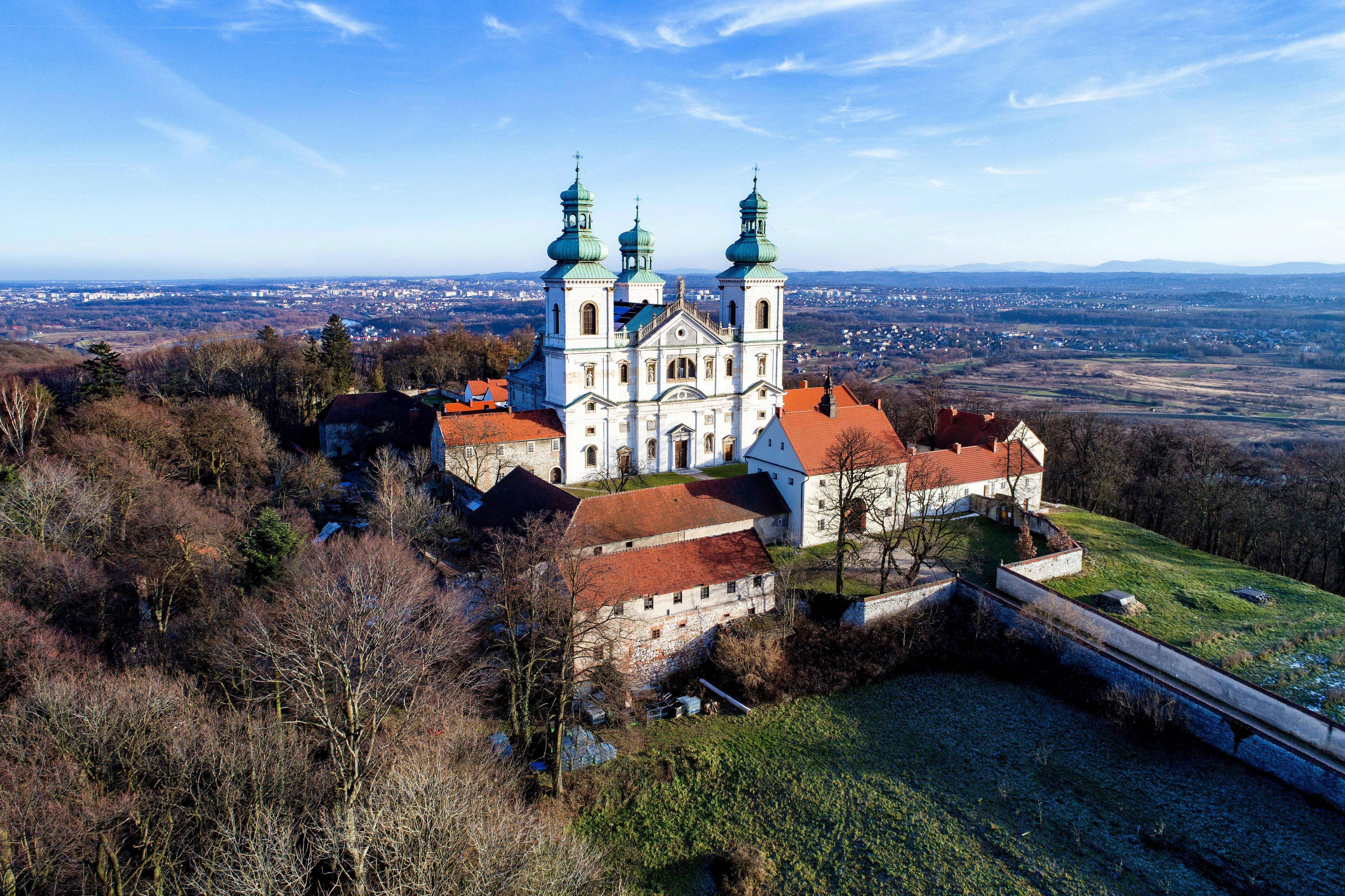 Camaldolese monastery and baroque church in the wood on the hill in Bielany, Krakow, Poland , Aerial view in winter with Vistula River and far view of Cracow city in the background