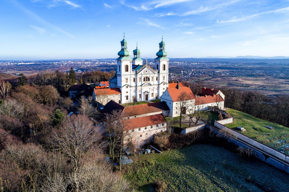Camaldolese monastery and baroque church in the wood on the hill in Bielany, Krakow, Poland , Aerial view in winter with Vistula River and far view of Cracow city in the background