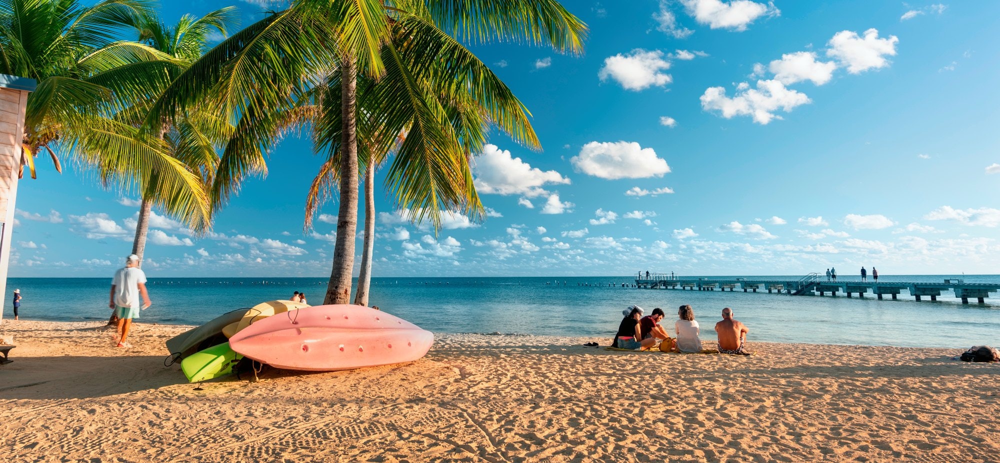 Key West, Florida - December 4, 2019:  People gather on the sand of Smathers Beach to watch the sunset in tropical Key West Florida USA