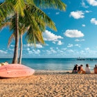 Key West, Florida - December 4, 2019: People gather on the sand of Smathers Beach to watch the sunset in tropical Key West Florida USA
