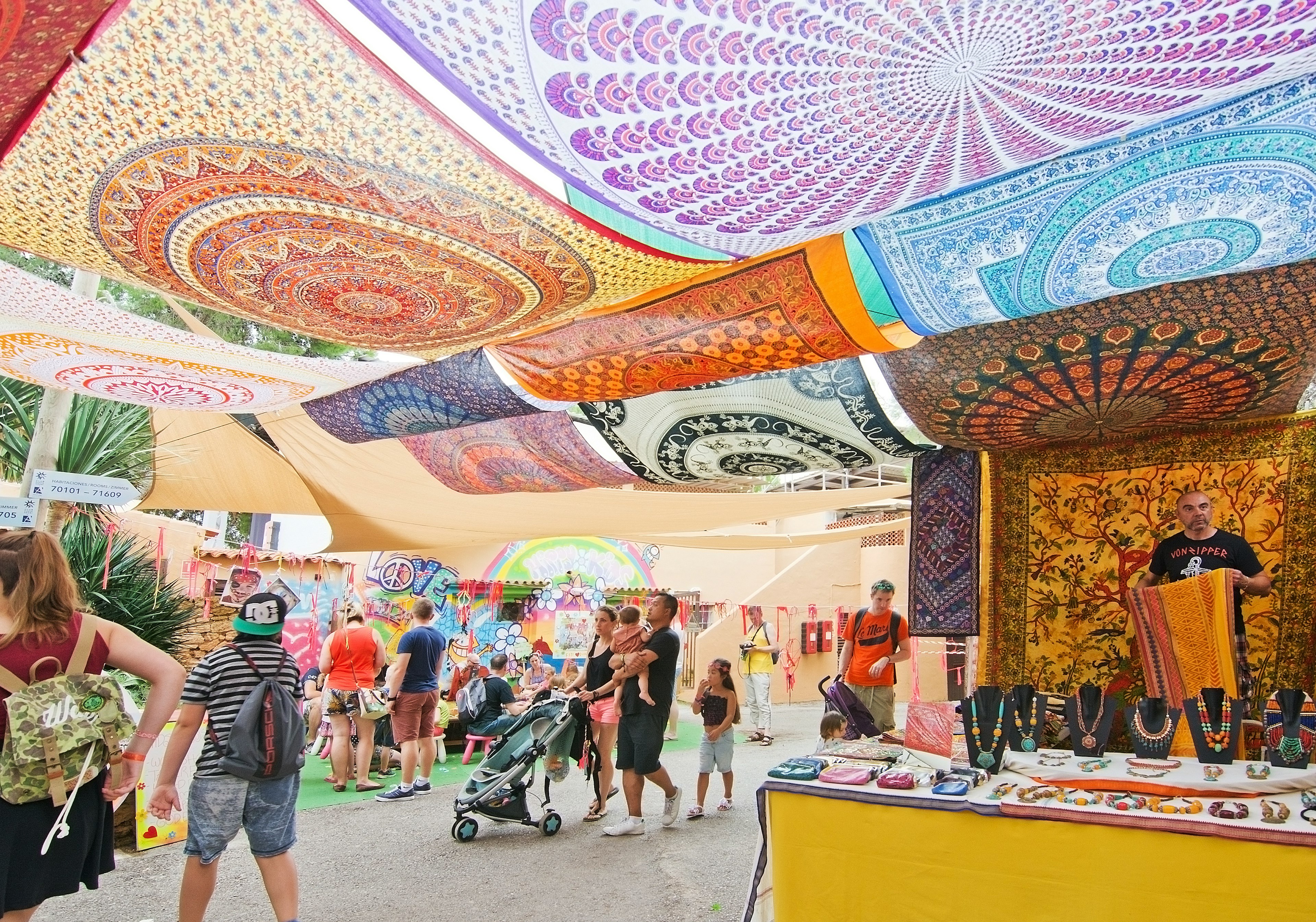 Es Canar, Ibiza, Balearic islands, Spain - October 26, 2016: Hippy Market people and vendors with ceiling made of colorful large fabric cloths on an overcast autumn day in October.