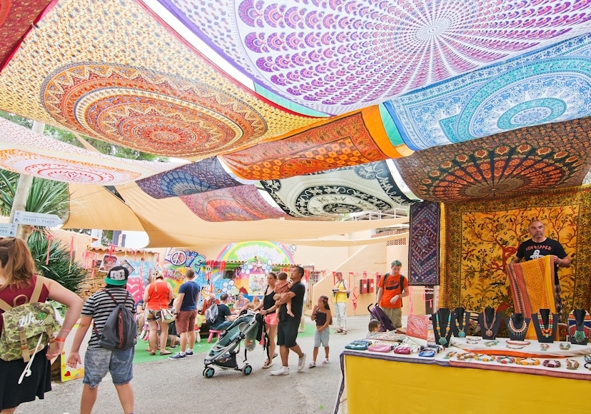 Es Canar, Ibiza, Balearic islands, Spain - October 26, 2016: Hippy Market people and vendors with ceiling made of colorful large fabric cloths on an overcast autumn day in October.