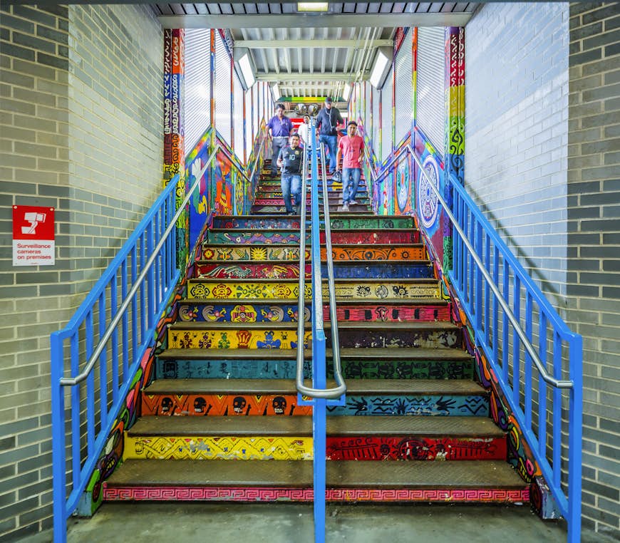 The exit steps of a metro station covered in brightly colored street art