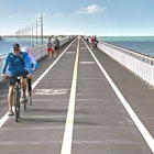 Visitors and residents bicycle and walk on the Florida Keys’ Old Seven Mile Bridge Wednesday, Jan. 12, 2022, in Marathon, Fla. The 110-year-old span formally opened Wednesday after a ceremony marked the completion of a four-year, $44 million restoration project. The old bridge originally was part of Henry Flagler’s Florida Keys Over-Sea Railroad that was completed in 1912. It later became the centerpiece of the Florida Keys Overseas Highway, but was replaced in 1982 with a new span. The old bridge is closed to vehicles but open to pedestrians and bicycles. FOR EDITORIAL USE ONLY (Andy Newman/Florida Keys News Bureau/HO)