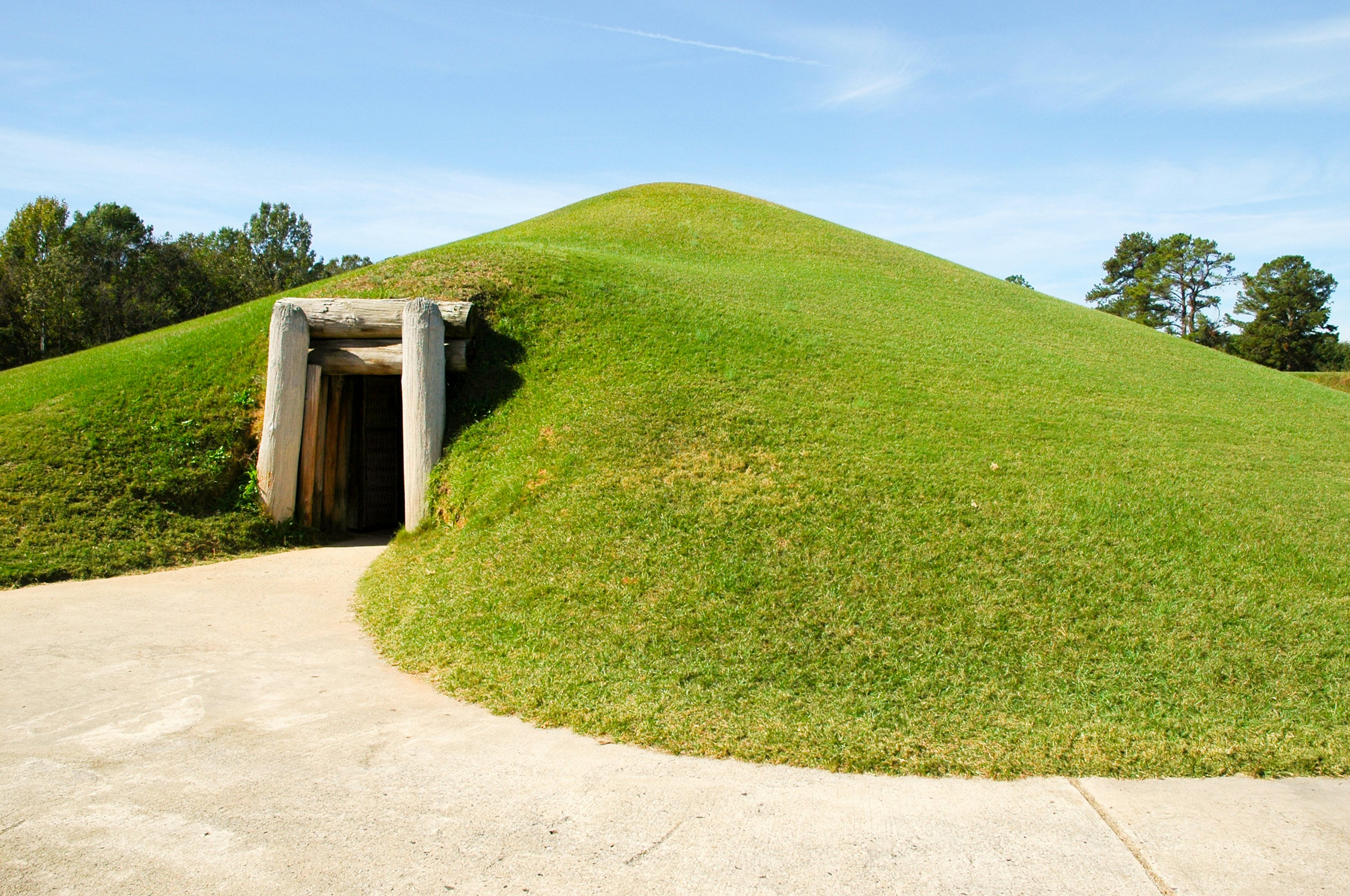 A green lawned mound with a doorway in it