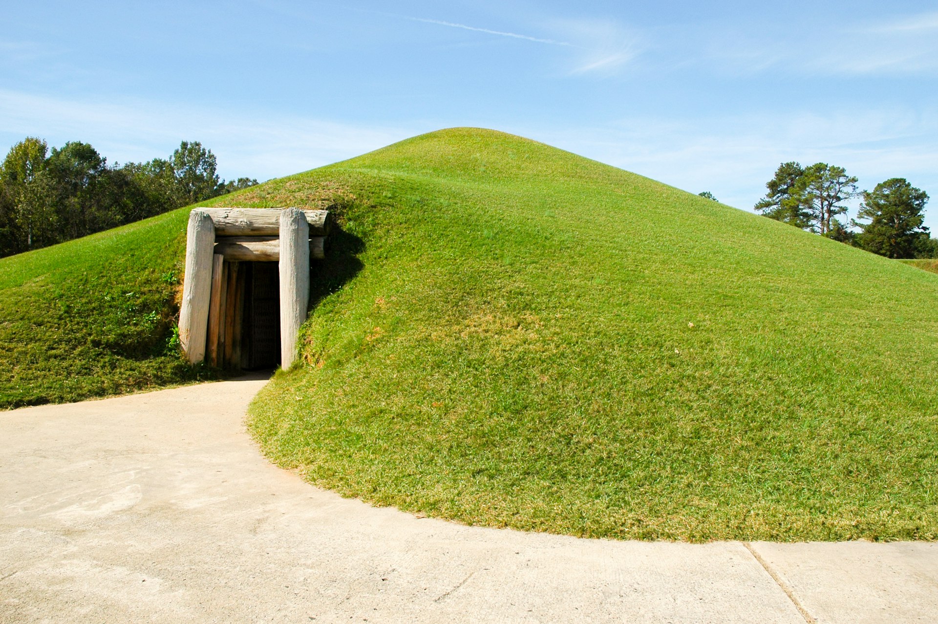 A green lawned mound with a doorway in it