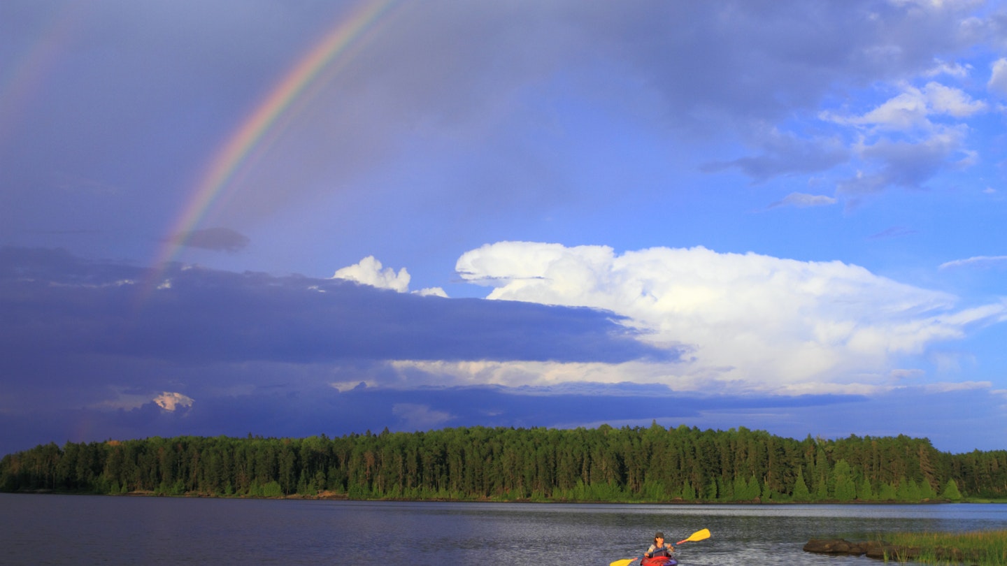 Woman canoeing in a beautiful lake with rainbow in the sky; Shutterstock ID 91903283; your: Claire Naylor; gl: 65050; netsuite: Online ed; full: Lakes Minnesota