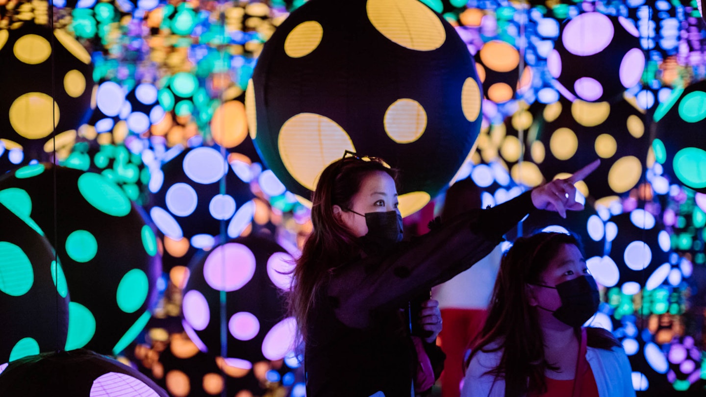 Visitor experiencing Yayoi Kusama’s Infinity Mirrored Room—My Heart Is Dancing into the Universe (2018), part of the 2022 exhibition One with Eternity: Yayoi Kusama in the Hirshhorn Collection at the Hirshhorn Museum and Sculpture Garden. Photo by Matailong Du. Wood and glass mirrored room with paper lanterns, 119 5/8 x 245 1/8 x 245 1/8 in. (304 x 622.4 x 622.4 cm). Courtesy Ota Fine Arts and Victoria Miro, London/Venice. © YAYOI KUSAMA.