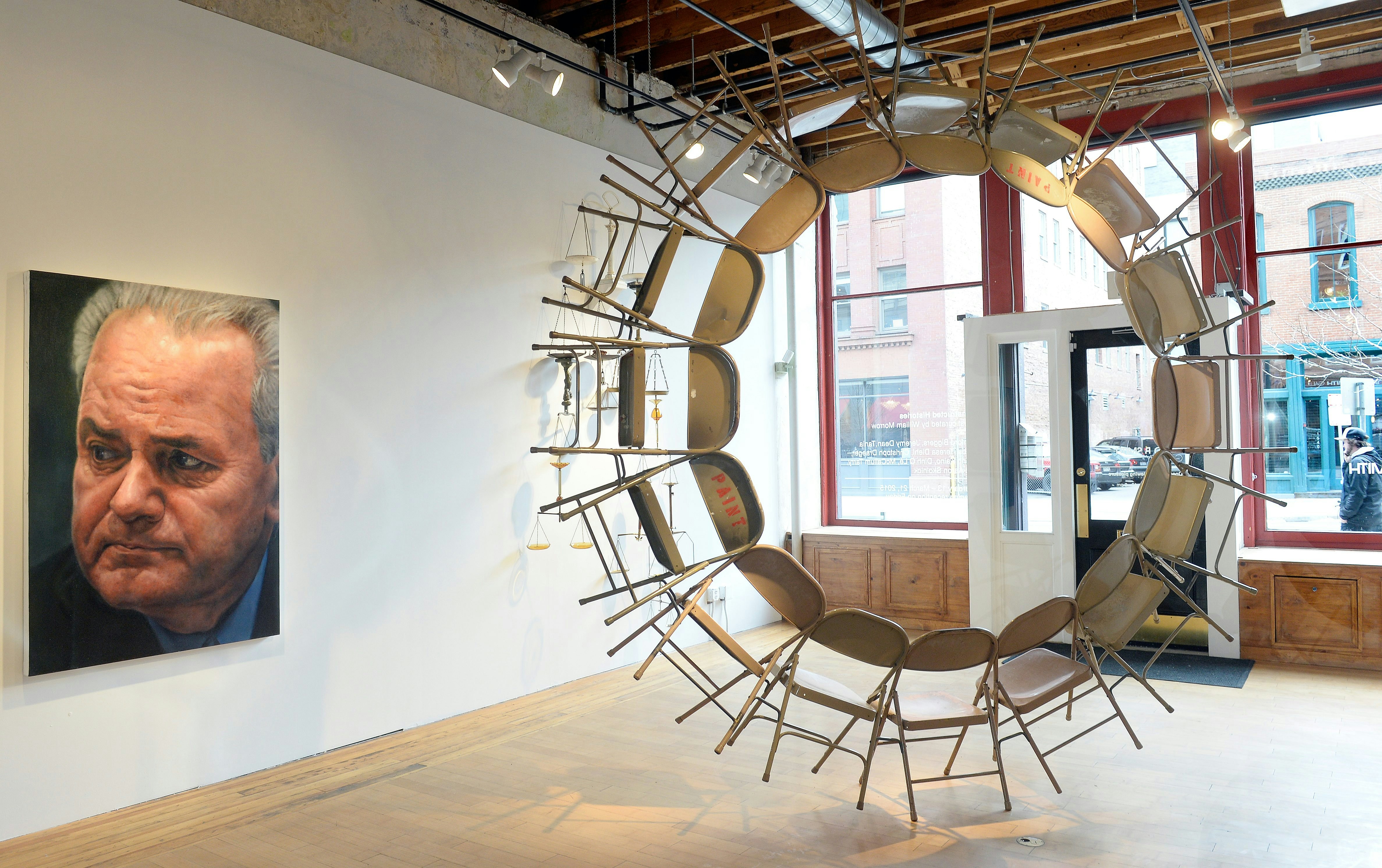 DENVER, CO - FEBRUARY  20:    Artist Bradley McCallum's   painting "Slobodan Milosevic" and Jeremy Dean's "Everything That Rises" made from 16 salvaged folding chairs greet visitors at the entrance at the new "Constructed Histories" exhibition at the David B. Smith Gallery at 1543 Wazee Street in LoDo Denver on Friday, February 20, 2015.  (Photo by Cyrus McCrimmon/The Denver Post via Getty Images )