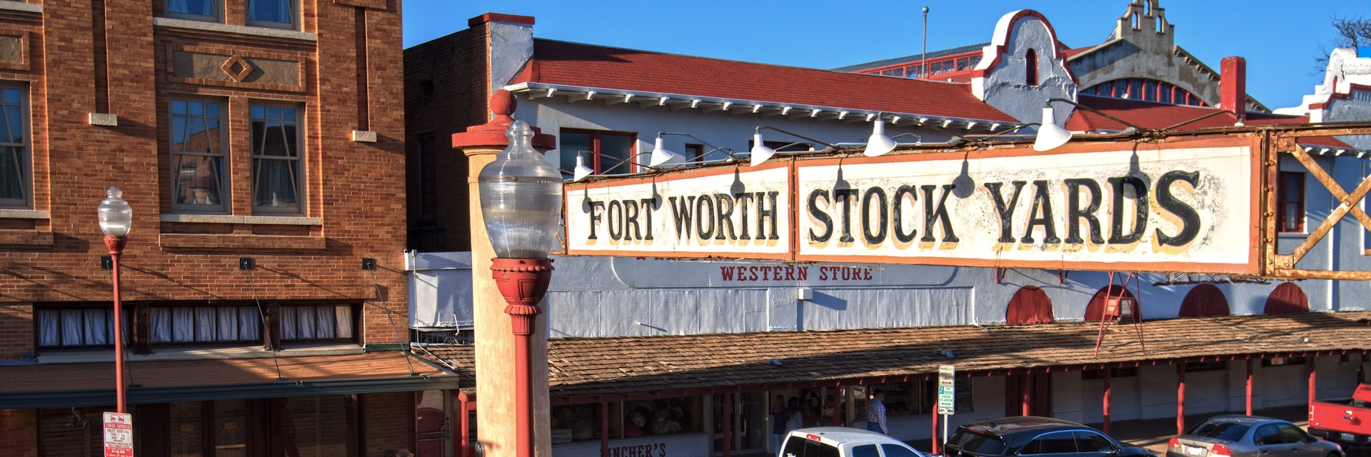 Rodeo cowboys and a low rider truck on Exchange Street in the Fort Worth Stockyards Historic District.  The district is listed on the National Register of Historic Places.