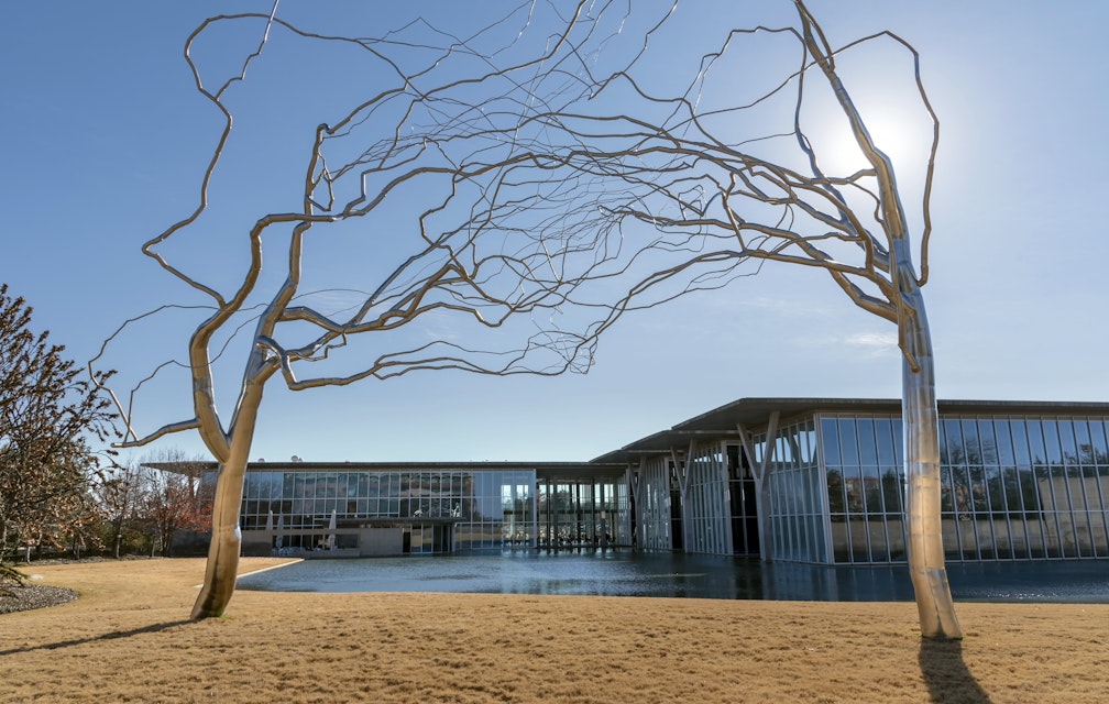 FORT WORTH, UNITED STATES - Dec 29, 2018: Roxy Paine Trees at Fort Worth Modern Art Museum  The stainless steel is bent into lifelike shapes  Also The museum and reflecting pond