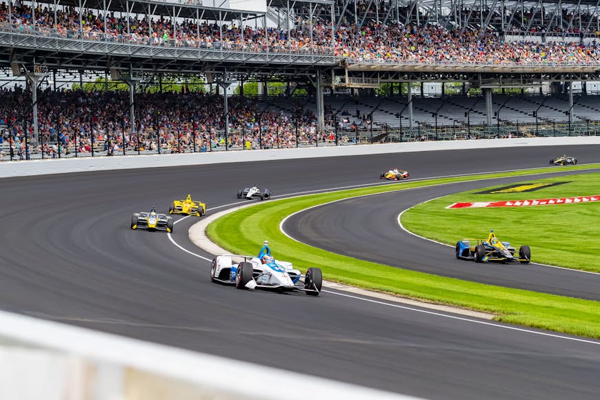 Автомобили участвуют в гонках по гоночной трассе Indianapolis Motor Speedway.