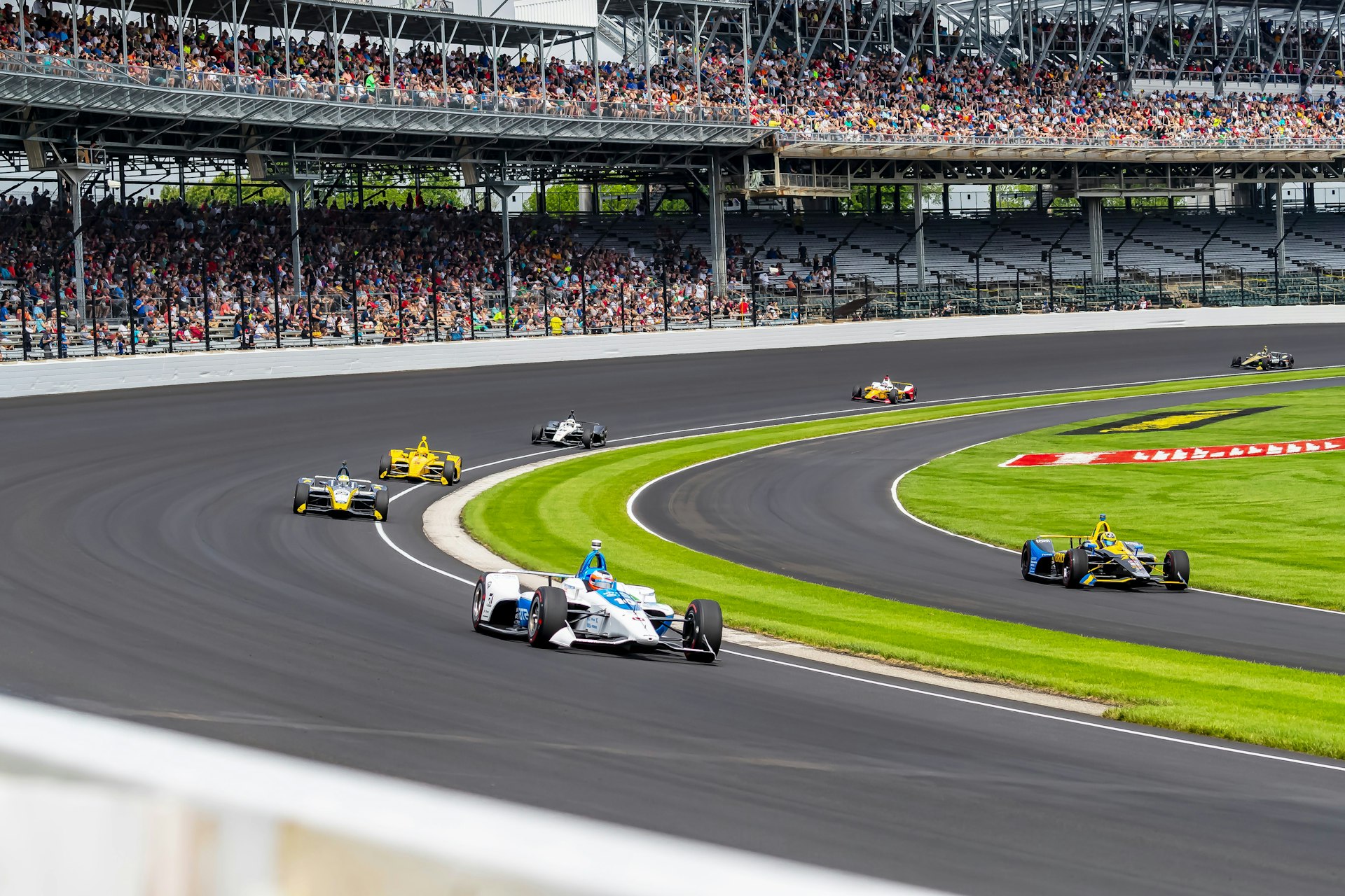 Cars race around the Indianapolis Motor Speedway